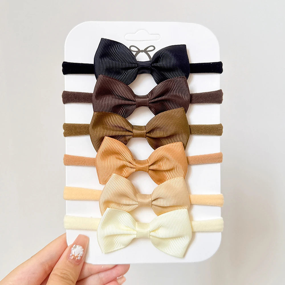 Un set di 5/6 elastici per capelli con fiocchi, per le bimbe