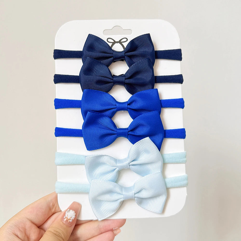 Un set di 5/6 elastici per capelli con fiocchi, per le bimbe