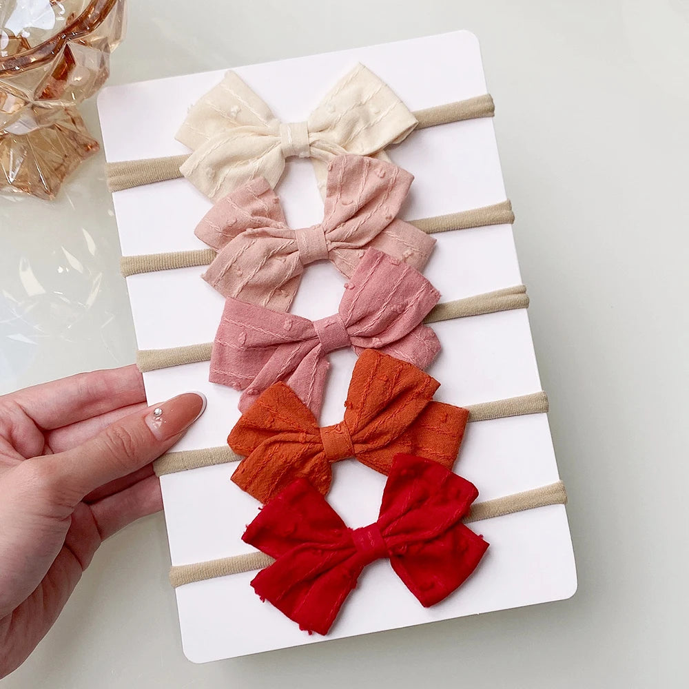 Un set di 5/6 elastici per capelli con fiocchi, per le bimbe