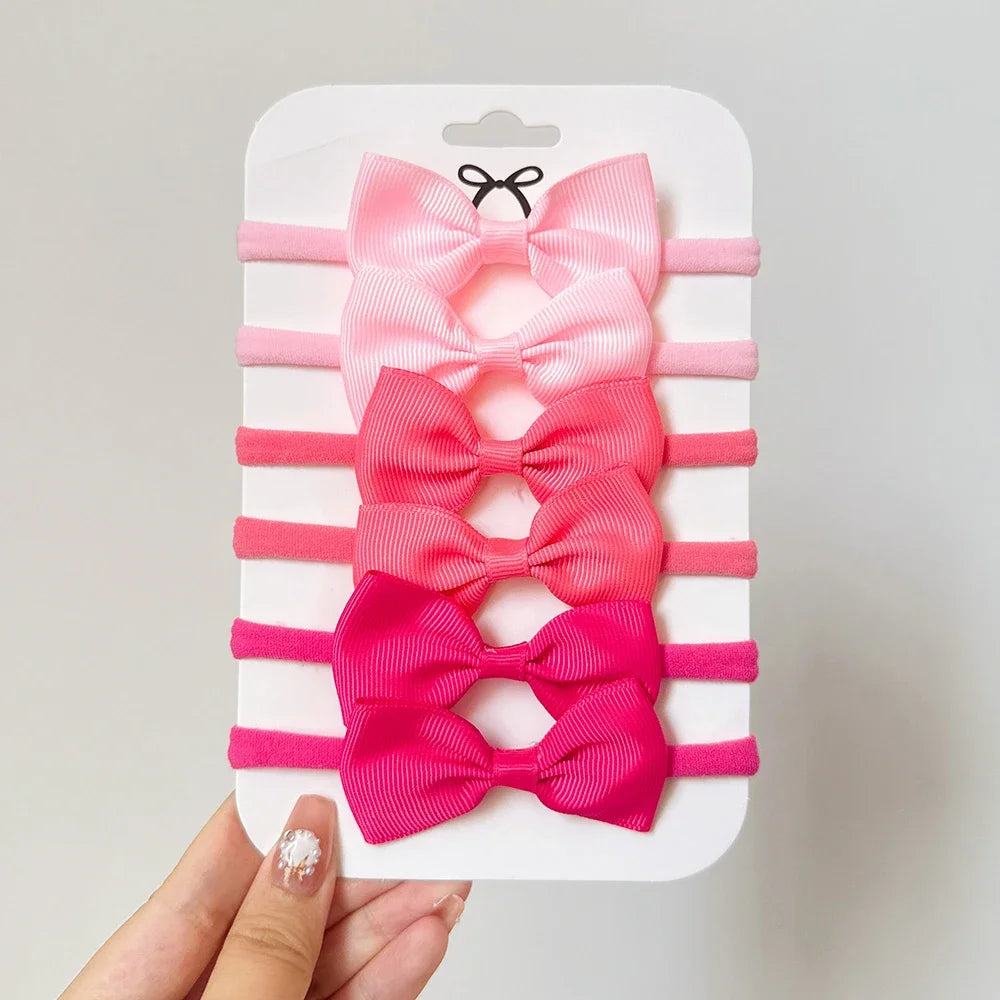 Un set di 5/6 elastici per capelli con fiocchi, per le bimbe
