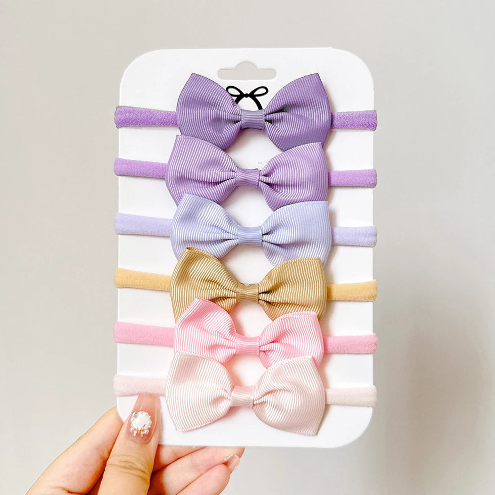 Un set di 5/6 elastici per capelli con fiocchi, per le bimbe