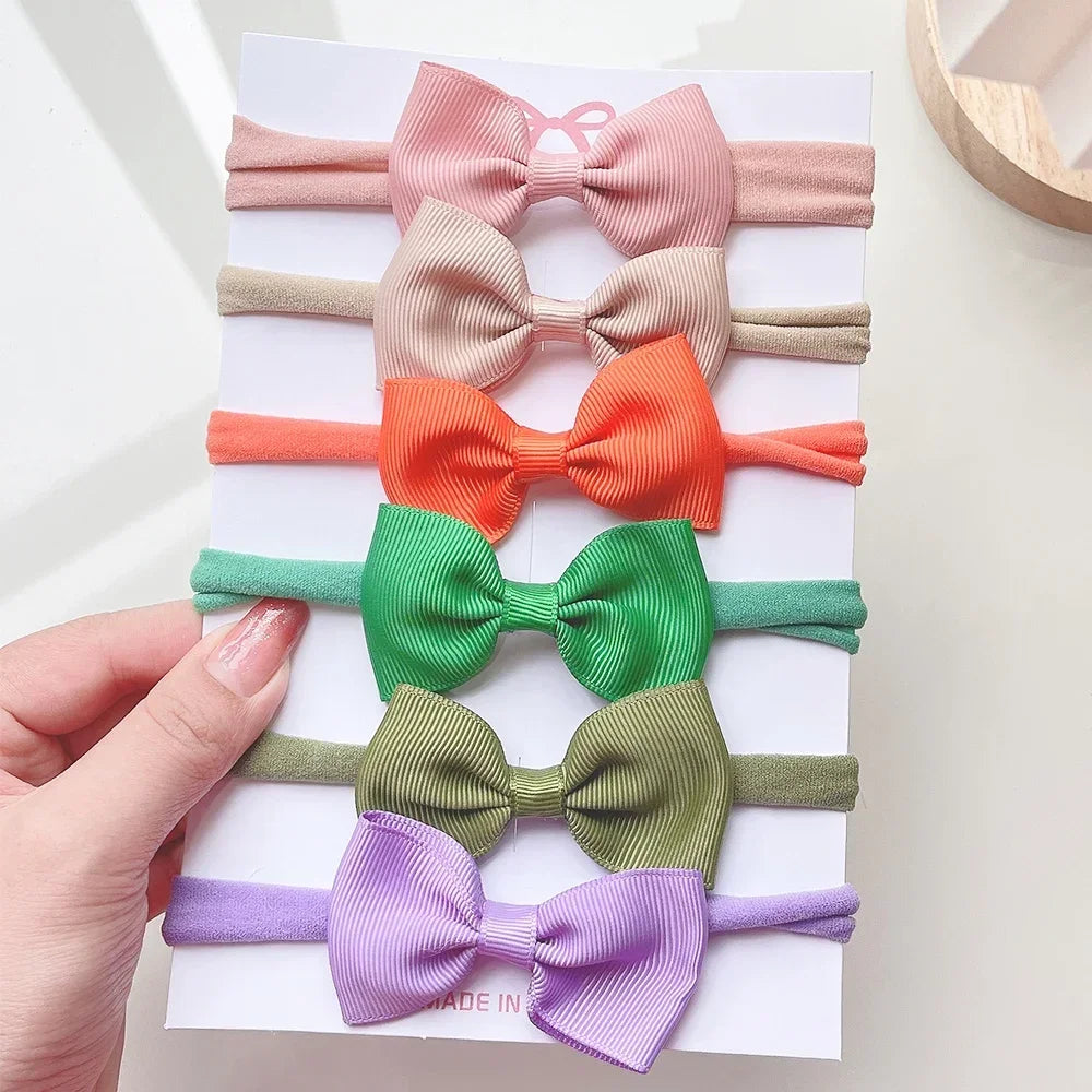 Un set di 5/6 elastici per capelli con fiocchi, per le bimbe